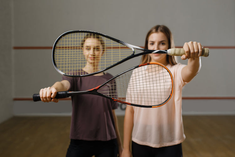dwie zawodniczki pokazuja rakiety squasha dziewczyny na treningu aktywne hobby sportowe trening fitness dla zdrowego stylu zycia
